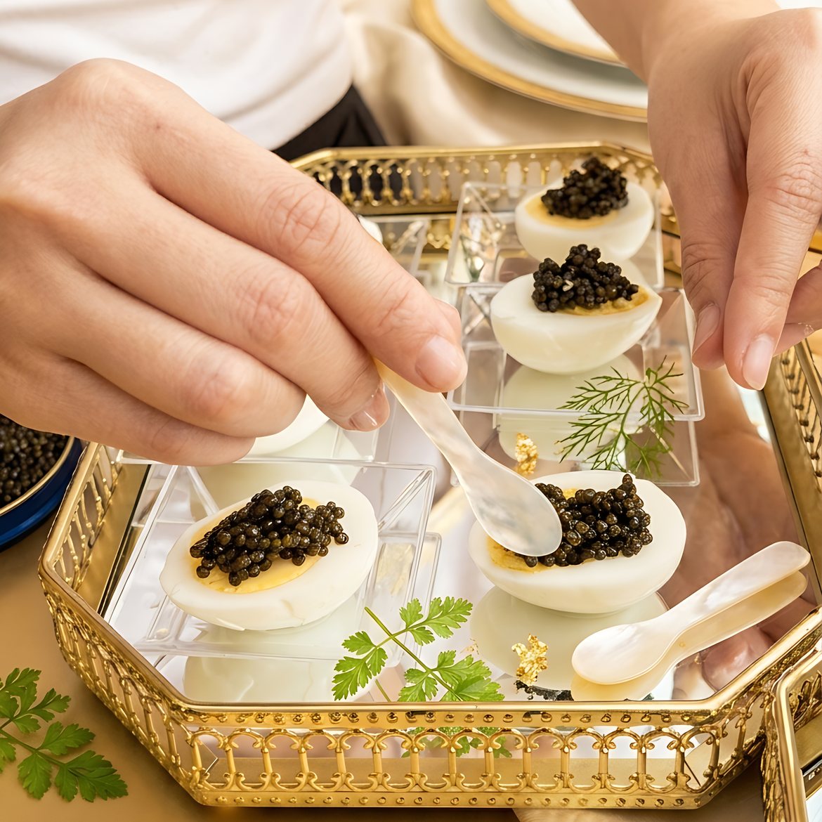 Caviar spooned onto halved eggs on a gold tray by One Sushi