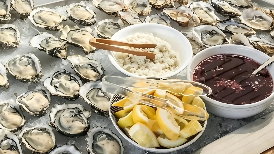 Freshly shucked oysters on ice with mignonette and lemons