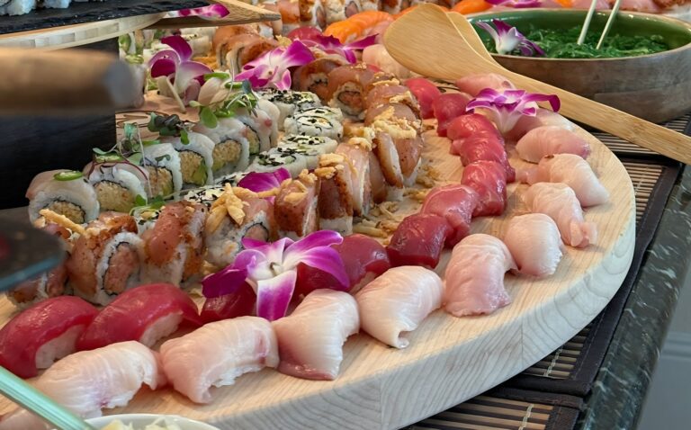 Platter of tuna and yellowtail nigiri and specialty rolls with orchids