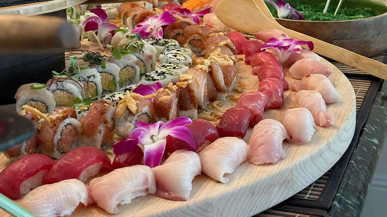Platter of tuna and yellowtail nigiri and specialty rolls with orchids